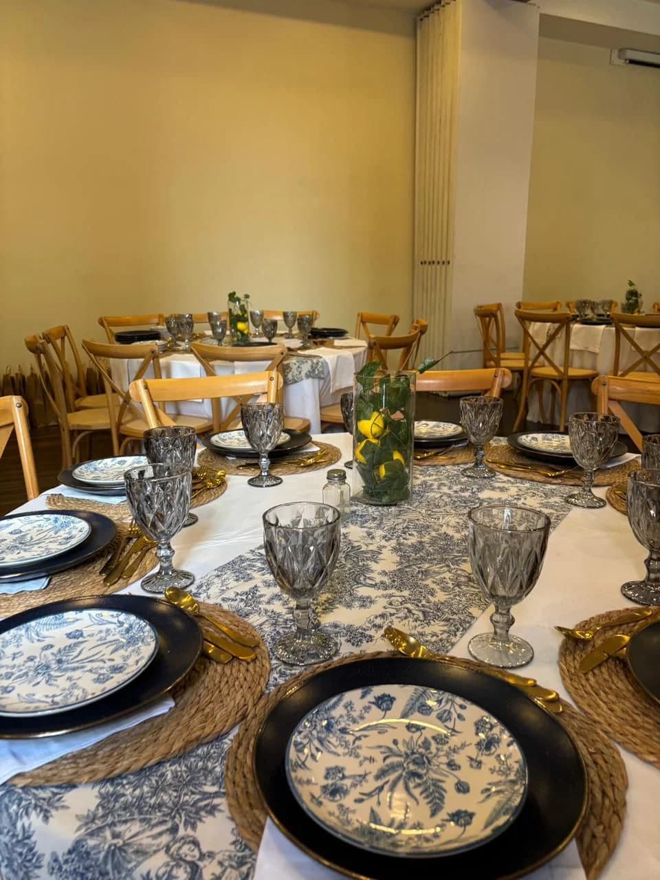 Montaje de salón con platos negros y mantel floral
